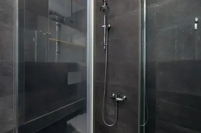a bathroom with a shower with a glass door at Sunny Studio Mostowa Krakow Kazimierz by Nolegi Renters in Kraków