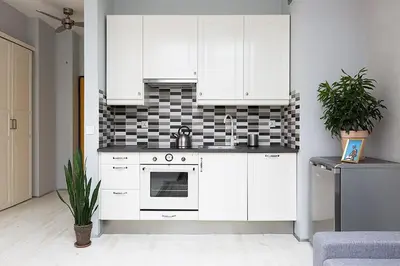 a white kitchen with white cabinets and a sink at Sunny Studio Mostowa Krakow Kazimierz by Nolegi Renters in Kraków