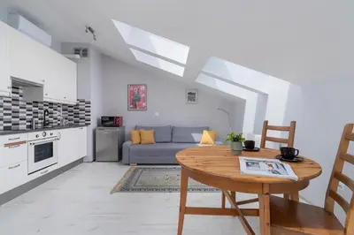 a kitchen and living room with a table and a couch at Sunny Studio Mostowa Krakow Kazimierz by Nolegi Renters in Kraków