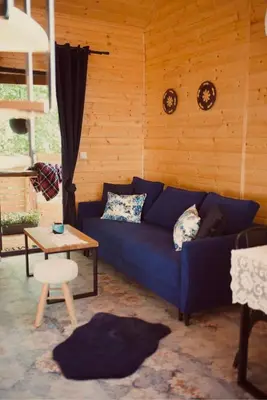 a living room with a blue couch and a table at Ranczo nad Cedronem in Kalwaria Zebrzydowska