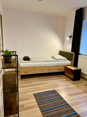 a small bedroom with a bed and a rug at Old Tree Home & Restaurant in Oświęcim