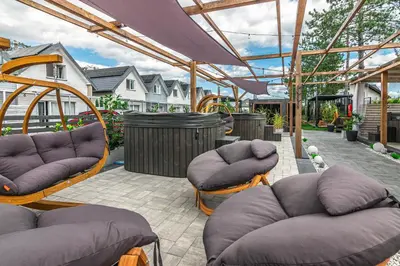 a patio with couches and chairs and a pergola at Old Tree Home & Restaurant in Oświęcim
