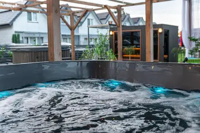a hot tub filled with water in a backyard at Old Tree Home & Restaurant in Oświęcim