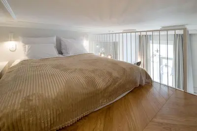 a bedroom with a large bed with a wooden floor at Polish design in Kraków
