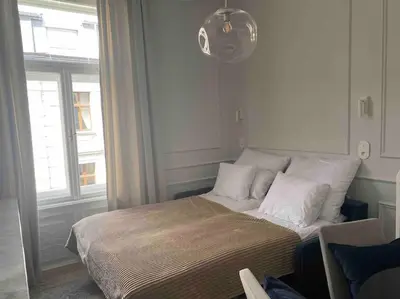 a bed with white pillows in a room with a window at Polish design in Kraków