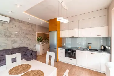 a kitchen and living room with white cabinets at Old Town Standard Apartment by BookingHost in Kraków