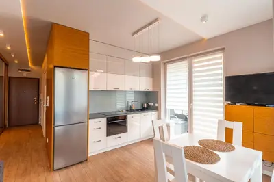 a kitchen with a white table and a refrigerator at Old Town Standard Apartment by BookingHost in Kraków