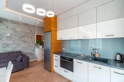 a kitchen with white cabinets and a couch at Old Town Standard Apartment by BookingHost in Kraków