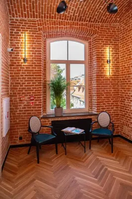 a brick room with a table and two chairs and a window at HOTEL TEATR in Kraków