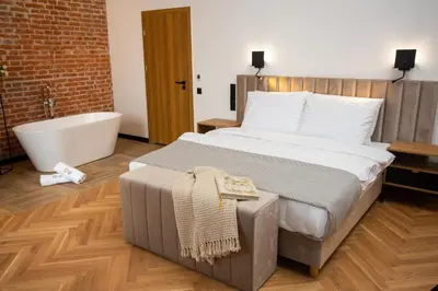 a bedroom with a large bed and a bath tub at HOTEL TEATR in Kraków