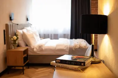 a pile of books on a table next to a bed at HOTEL TEATR in Kraków