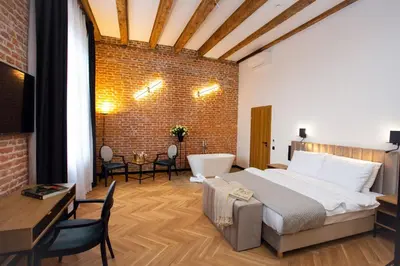 a bedroom with a large bed and a brick wall at HOTEL TEATR in Kraków