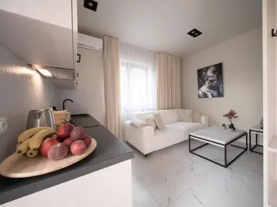 a kitchen and living room with a plate of fruit on a counter at Sweet Dreams Apartment in Zator
