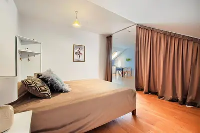 a bedroom with a large bed in a room at ArPioNa dom nad jeziorem z jacuzzi, sauną i placem zabaw in Dąbrówka