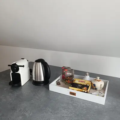 a table with a coffee maker and a coffee pot and a tea kettle at ArPioNa dom nad jeziorem z jacuzzi, sauną i placem zabaw in Dąbrówka