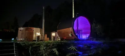 a building with a purple light on it at night at ArPioNa dom nad jeziorem z jacuzzi, sauną i placem zabaw in Dąbrówka