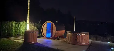 a small wooden boat with two trash cans at night at ArPioNa dom nad jeziorem z jacuzzi, sauną i placem zabaw in Dąbrówka