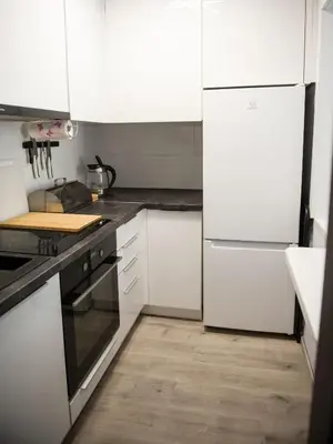 a kitchen with white appliances and a wooden floor at Pod Wielorybem in Jaworzno