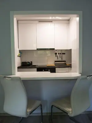 two chairs in front of a kitchen counter with white cabinets at Pod Wielorybem in Jaworzno