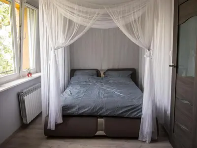 a bed with a canopy in a bedroom with a window at Pod Wielorybem in Jaworzno