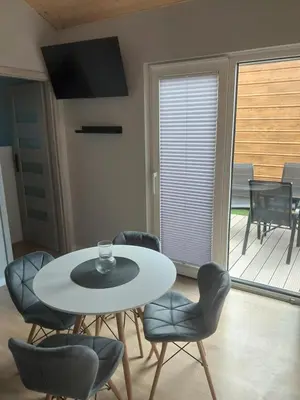 a dining room with a table and chairs and a balcony at DOMKI#ENERGY Zator in Przeciszów