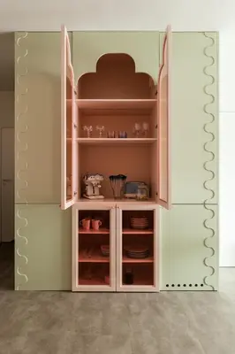 a cupboard in a kitchen with some dishes in it at Pops Apartment in Kraków