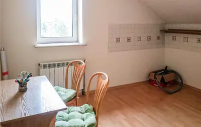 a dining room with a table and chairs and a window at 3 Bedroom Awesome Apartment In Klucze in Klucze