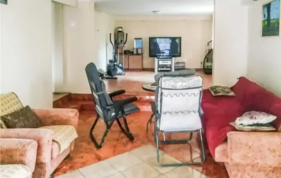 a living room with a couch and chairs and a tv at 3 Bedroom Awesome Apartment In Klucze in Klucze