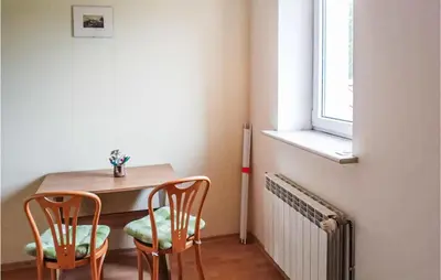 a dining room table with two chairs and a window at 3 Bedroom Awesome Apartment In Klucze in Klucze