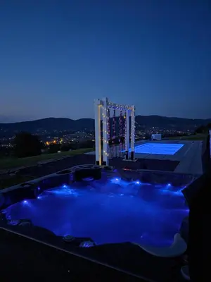 a hot tub at night with a roller coaster at Lipowe Apartmenty in Limanowa