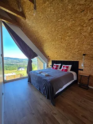 a bedroom with a large bed and a large window at Lipowe Apartmenty in Limanowa