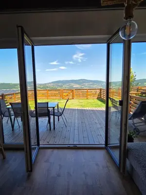 a screened in porch with a view of the mountains at Lipowe Apartmenty in Limanowa