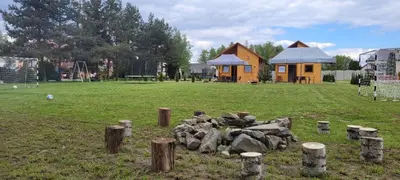 a yard with a pile of logs and a house at Noclegi u Eli Zator Energylandia in Zator