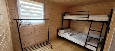 two bunk beds in a wooden cabin with a window at Noclegi u Eli Zator Energylandia in Zator