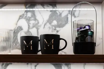 two black coffee mugs sitting on a shelf at Old Town G6 by M Apartments in Kraków