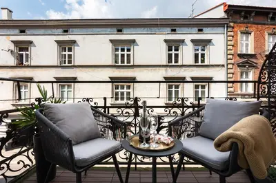 a balcony with two chairs and a table and a building at Old Town G6 by M Apartments in Kraków