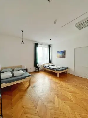 a room with two beds and a wooden floor at Nice View Rooms In Old Town in Kraków