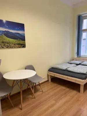 a bedroom with a bed and a table and chairs at Batorego Lovely Rooms in Kraków