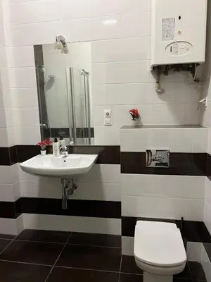 a bathroom with a sink and a toilet at Batorego Lovely Rooms in Kraków