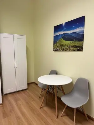 a room with a table and two chairs and a cabinet at Batorego Lovely Rooms in Kraków
