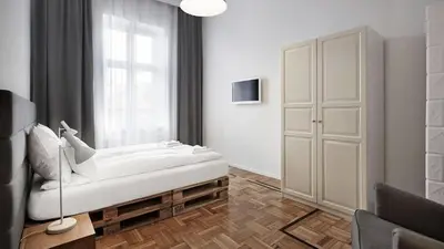 a living room with a bed and a window at CityNest Apartments in Kraków
