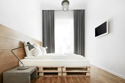 a white bedroom with a bed and a window at CityNest Apartments in Kraków
