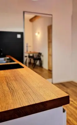 a wooden counter top in a room with a table at CityNest Apartments in Kraków