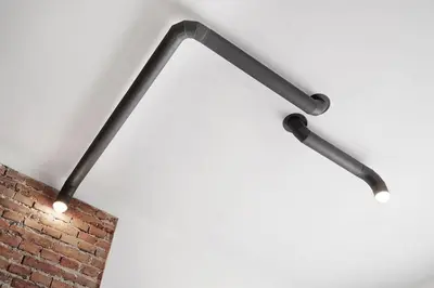 a group of three lights hanging from a wall at CityNest Apartments in Kraków