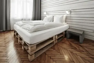 a bedroom with a large bed on a wooden floor at CityNest Apartments in Kraków