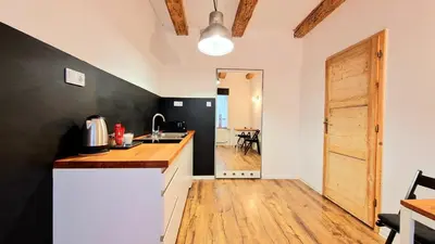 a kitchen with white counters and a wooden floor at CityNest Apartments in Kraków