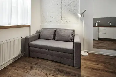 a couch in a living room with a lamp at CityNest Apartments in Kraków