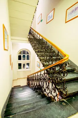 a spiral staircase in a building with green steps at CityNest Apartments in Kraków