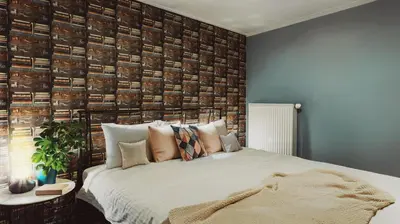 a bedroom with a bed and a wall of books at Jana Apartments in Kraków