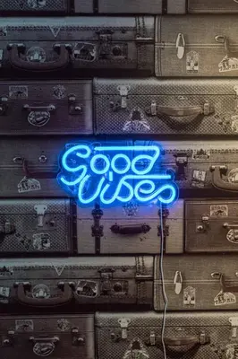 a neon sign on a pile of suitcases at Jana Apartments in Kraków